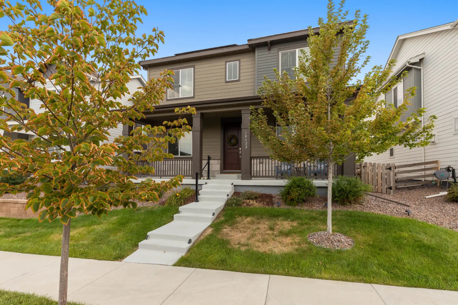 Front entry of 10622 Truckee Street, Commerce City framed by a young shade tree